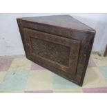 An antique hanging corner cupboard with worked leather front