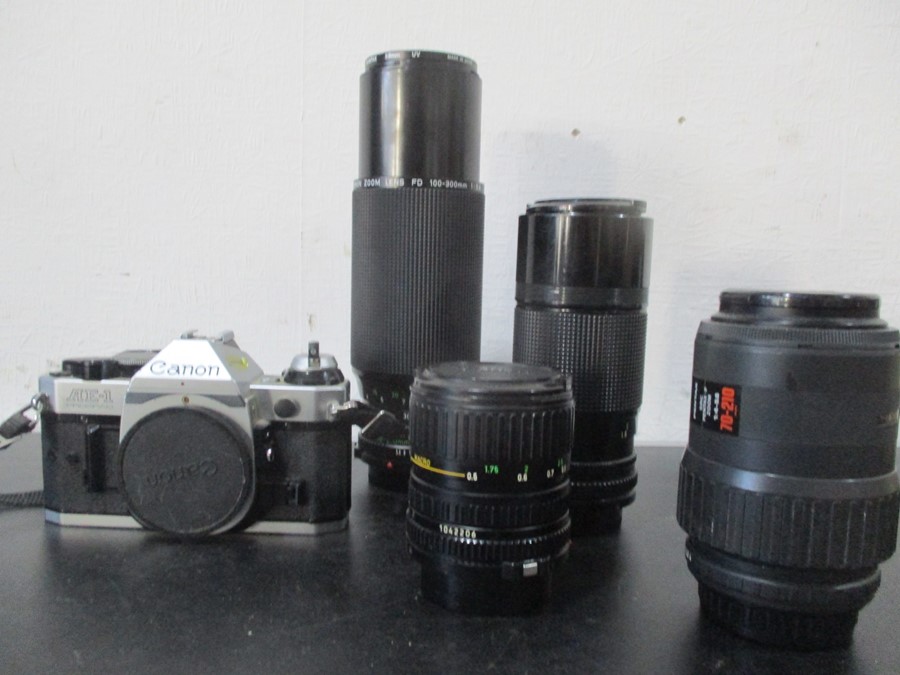 A Canon AE-1 camera with Canon and Pentax lenses