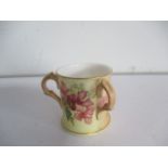 A Royal Worcester blush ivory three handled cup
