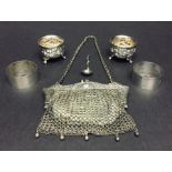 A silver plate mesh purse, silver serviette rings and salts.