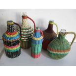 A collection of five Hungarian mining bottles with brightly coloured coverings