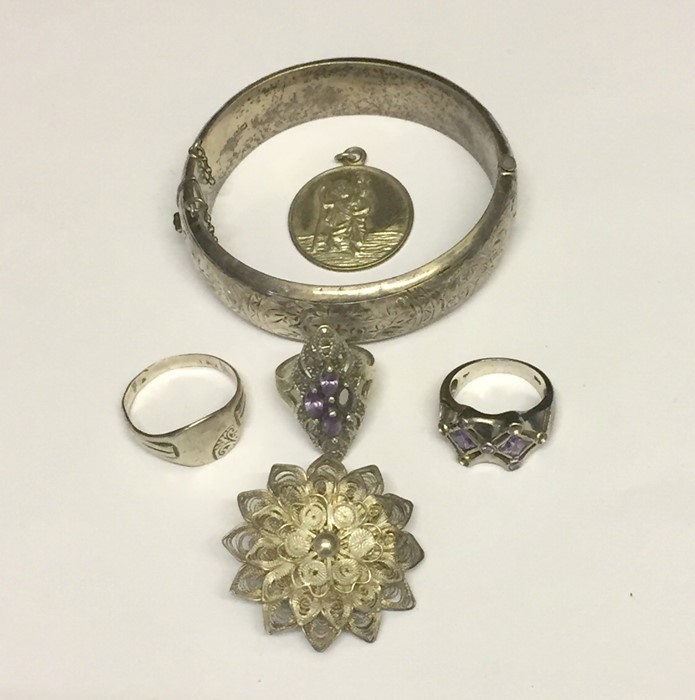 A silver bangle, silver rings, pendant etc