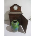 A small set of drawers along with a peacock design studio pottery vase and a mantle clock