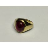 An unmarked gold (probably 18ct) child's ring set with a cabochon ruby