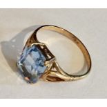A 9ct gold ring with emerald cut blue coloured stone.