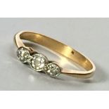 A diamond three stone ring set in unmarked gold.