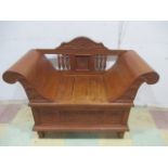 An oriental carved wooden bench with scroll ends