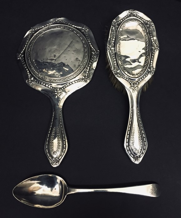 A hallmarked silver mirror and brush along with a Georgian silver spoon.