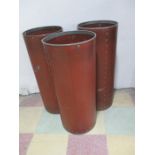 A set of three round factory bins