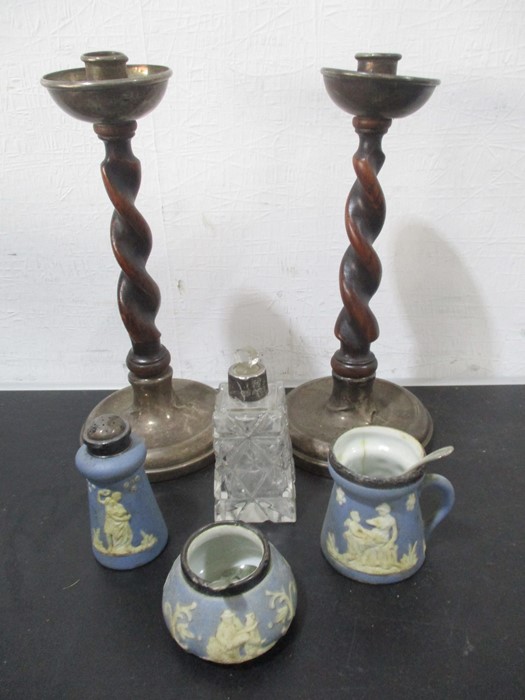 A pair of oak barley twist candlesticks with hallmarked silver sconces and bases along with a