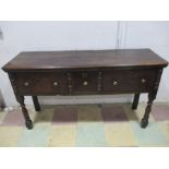 An antique oak dresser base with three drawers