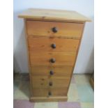 A narrow pine chest of six drawers