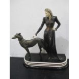 An Art Deco spelter and ivorine figure group of a lady walking a greyhound, signed Menneville-