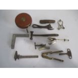 A collection of various items including leather case tape measure, clockwork key, nut cracker, pen