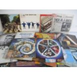 A collection of vinyl records including The Beatles, David Bowie, Queen, Pink Floyd etc