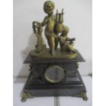 A black slate chiming mantle clock surmounted by brass cherubs