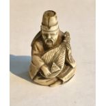 A 19th Century ivory Netsuke of a seated man playing the lute