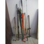 A collection of fishing rods, along with two cast iron fishing rod holders