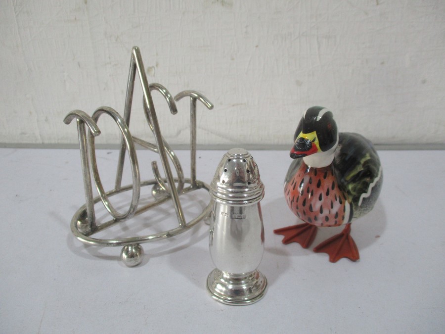 A hallmarked silver pepperette along with a novelty silver plated toast rack and a figure of a duck