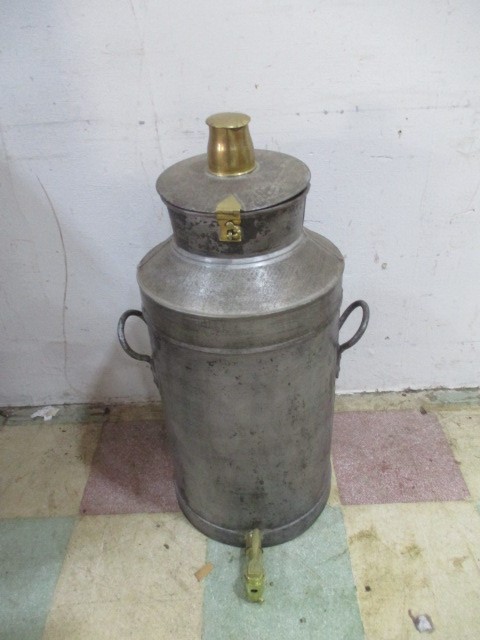 A vintage milk churn with breather top and brass tap.