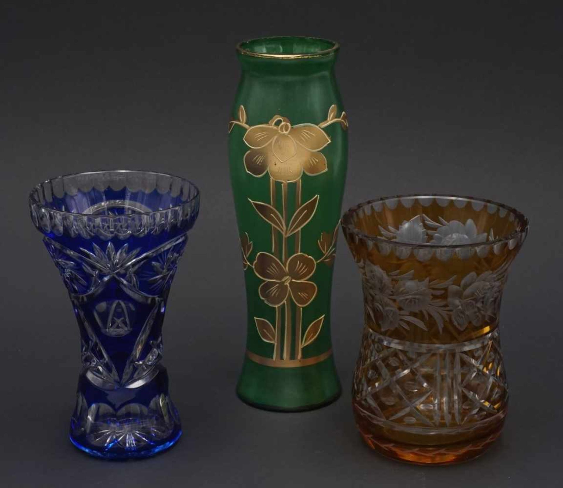 Drei Glasvasen1) Kristallglas, reich verschliffen, H. 12,5 cm 2) grün, goldene, florale