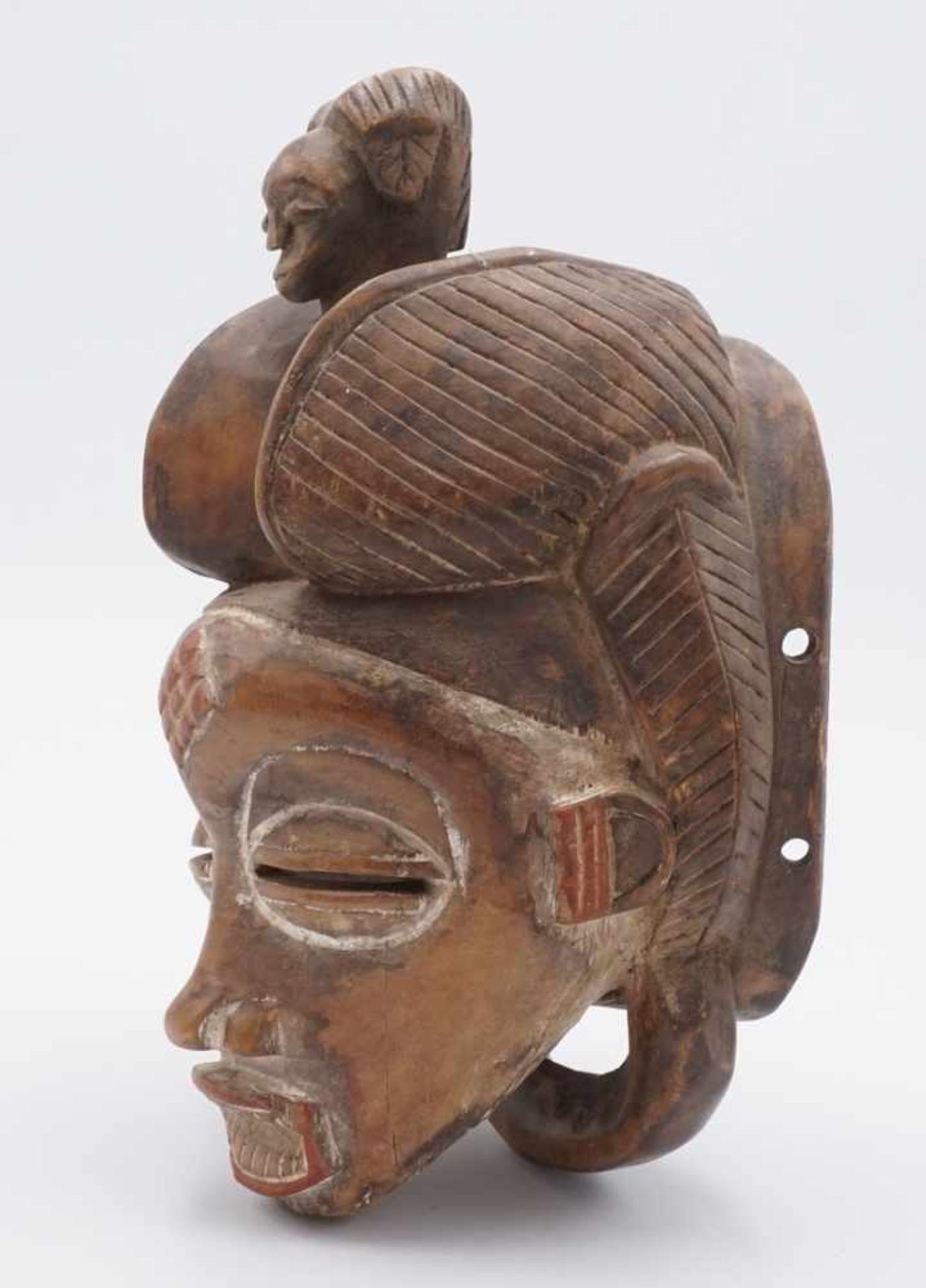 Maske der Senufo, Burkina Faso, 20. Jh.Holz, Vorhaltemaske mit Figur auf dem Kopf, Augenschlitzen