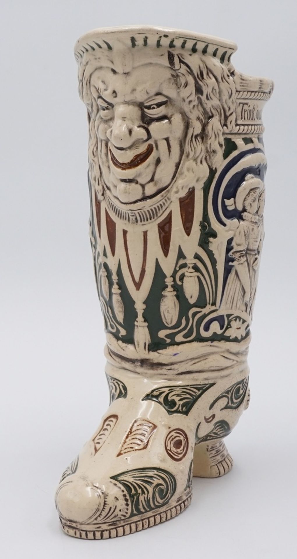 TrinkstiefelGründerzeit, Keramik reliefiert, Schauseite mit Groteskenkopf, Spruch "Trink aus