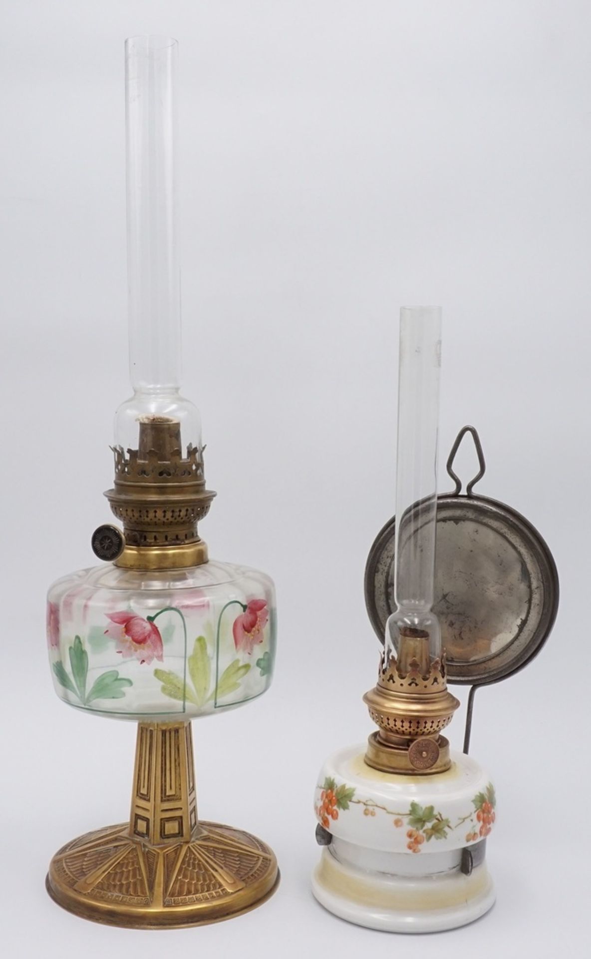 Zwei Petroleumlampen, um 19001) Jugendstil Tischpetroleumlampe, reliefierter Messingfuß,