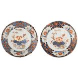 Two large Chinese Imari plates, decorated in the centre with a willow near a lotus pond, the border