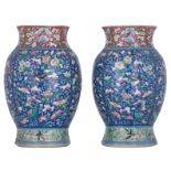 A pair of Chinese blue ground famille rose floral decorated lantern shaped vases, with a lobed mouth