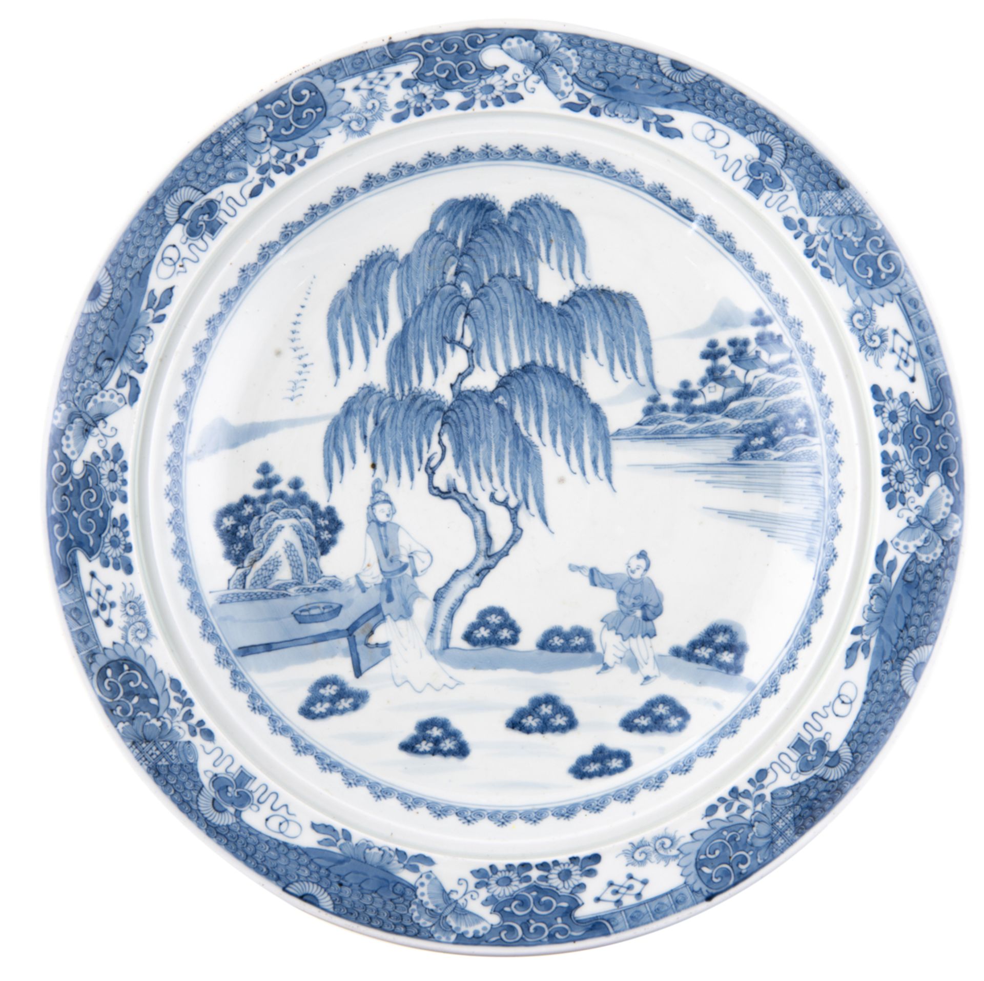 A large Chinese deep charger, blue and white decorated with figures in a garden near a willow tree,