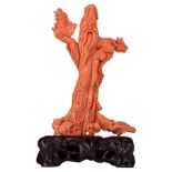 A fine red coral sculpture, depicting Tsai Shen Yeh, the God of Wealth, on a matching hardwooden bas