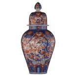 A large Japanese Arita Imari covered jar, decorated with flower sprays and with two large panels, fi
