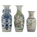 A Chinese polychrome vase, decorated with an animated scene; added a ditto famille rose vase, decora