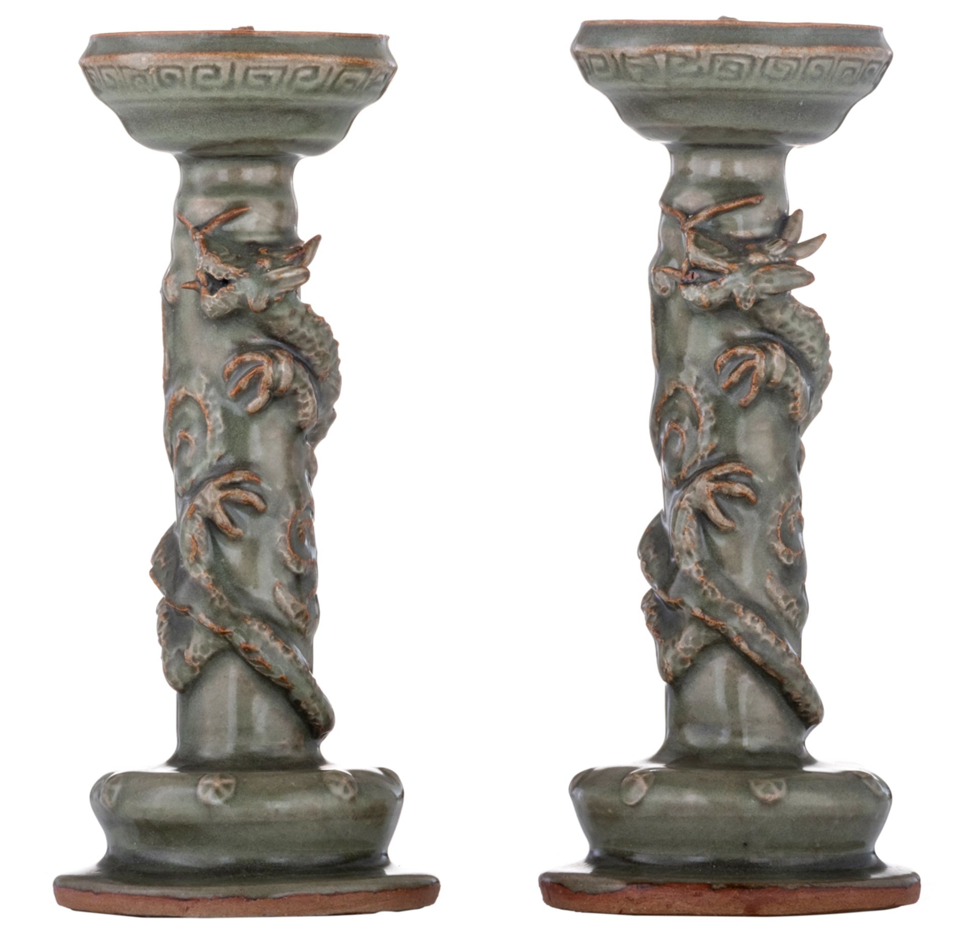 A pair of Chinese celadon stoneware candlesticks, relief decorated with three clawed dragons, Longqu