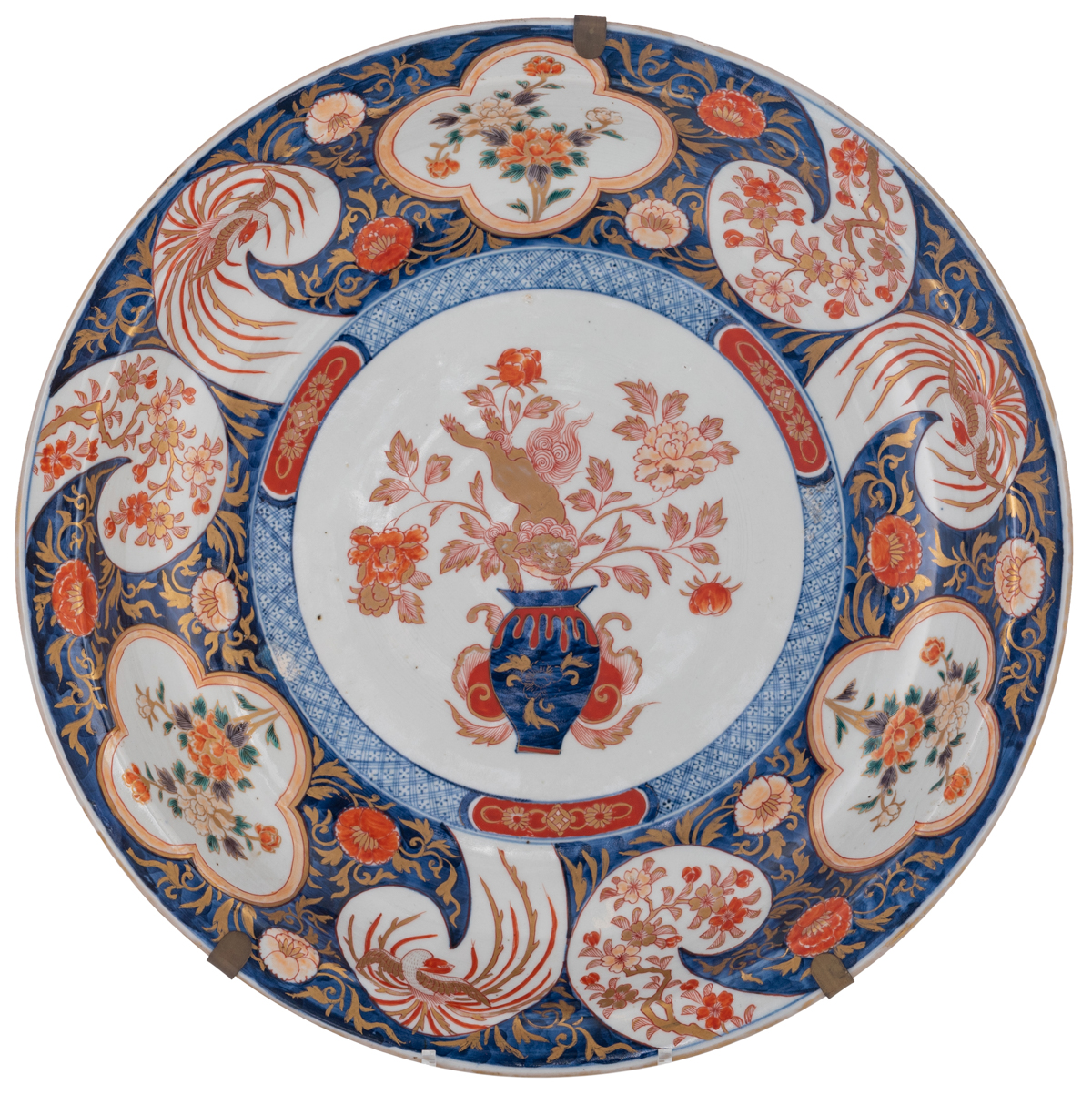 A large Japanese Arita Imari plate, decorated in the centre with a lion jumping on a flower basket,