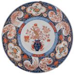 A large Japanese Arita Imari plate, decorated in the centre with a lion jumping on a flower basket,