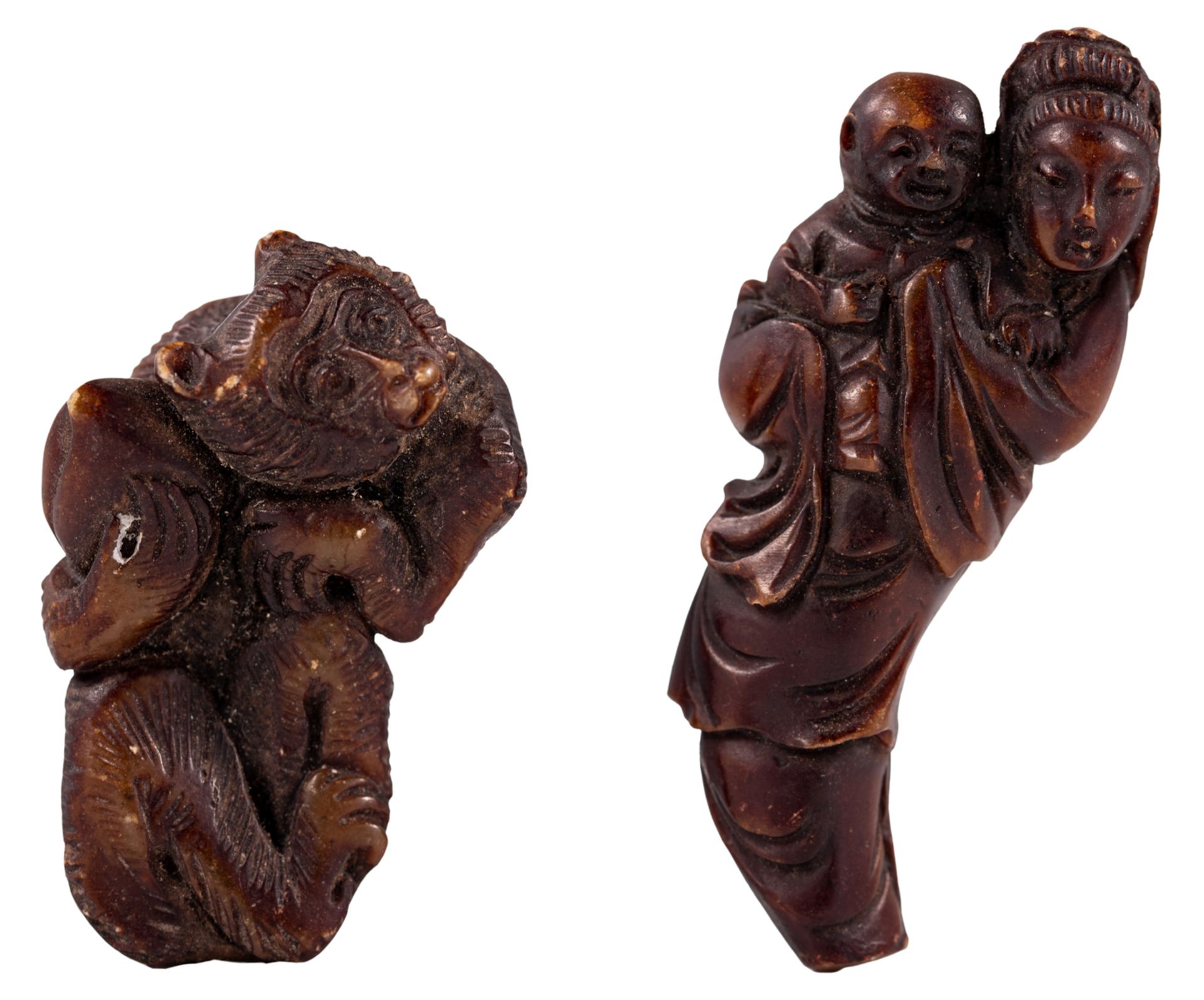A lot of two horn netsukes, one depicting a monkey, holding a peach, and the other depicting a woman