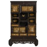 An imposing richly carved Meiji period Japanese cabinet, decorated with mother-of-pearl, ivory and