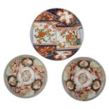 A Japanese Arita Imari porcelain charger depicting a lady in a garden settting; added two Arita