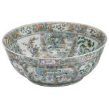 An exceptionally large Chinese famille verte bowl, decorated with various court and animated scenes,