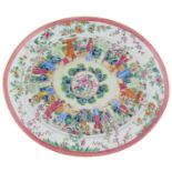 A Chinese famille rose oval shaped plate, decorated with flowers and figures in a garden, the top