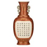 A Chinese coral ground wall vase, the roundels with a text enclosed by gilt decorated lotus scrolls,