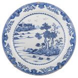 A Chinese blue and white charger, the well decorated with trees in a river landscape, ø 54,5 cm