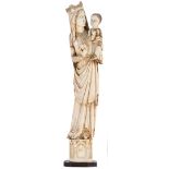 An early 20thC Gothic revival patinated ivory sculpture depicting Our Lady and Child, on an oak