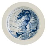 A Chinese blue and white wash basin, the well decorated with fish and a dragon amongst the waves,