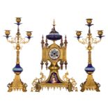 A three-piece French Gothic Revival garniture, with gilt bronze and polychrome decorated porcelain