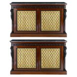 A pair of mahogany veneered Regency side cabinets with ebonised leopard monopodia and a leaf border,