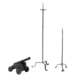 Two wrought iron church candelabras, H 98 - 152 cm; added a cast iron cannon on its matching base, H
