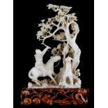 A Chinese ivory sculpture depicting a hunting scene, on a richly carved wooden base, second